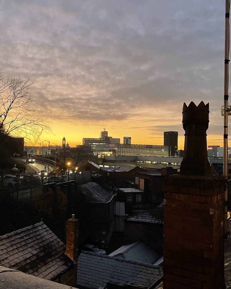Stockport rooftops and chimney pots at dusk, looking across to the town centre